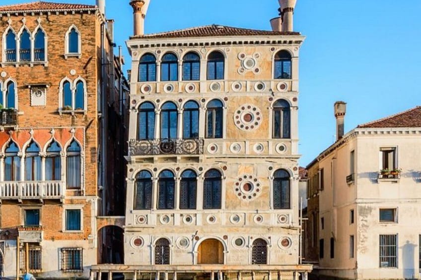 A historic building with arched windows and decorative stonework. 1