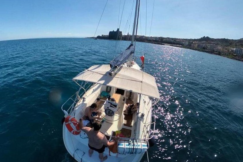 Un voilier sur des eaux calmes, sous un ciel dégagé, avec une côte visible au loin. 4