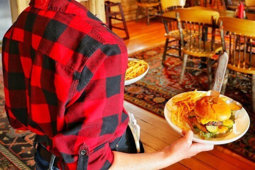 Una persona sosteniendo un plato con una hamburguesa y papas fritas. 2