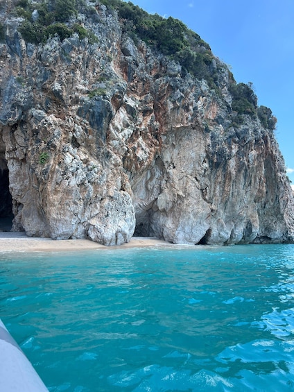 A rocky coastline with clear turquoise waters and a sandy beach. 2