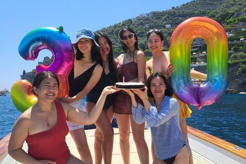 A group of people on a boat with colorful inflatable numbers. 4