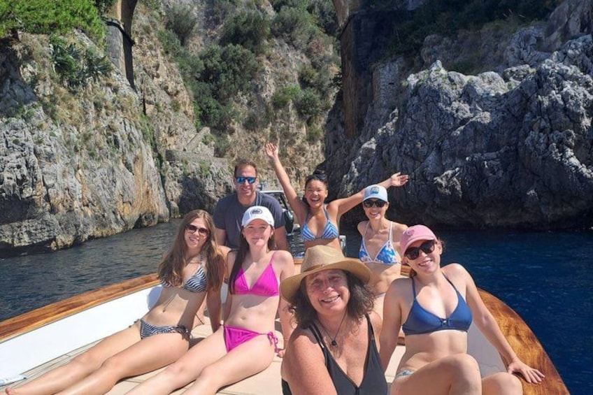 Un gruppo di persone su una barca vicino a scogliere rocciose. 1