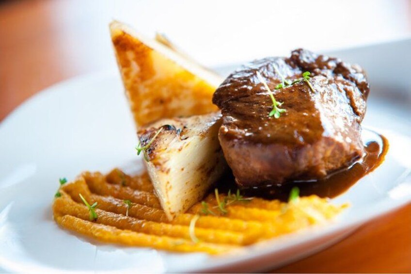 A plate with a steak, mashed potatoes, and a side of what appears to be a puree or sauce. 3