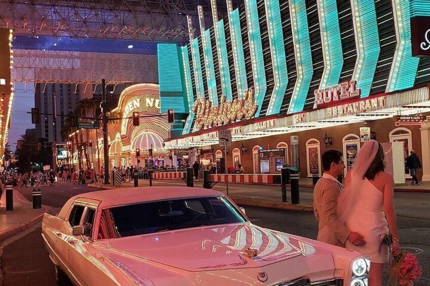 Un casino aux néons éclatants, illuminé de mille feux, avec une voiture ancienne garée devant l’entrée. 5