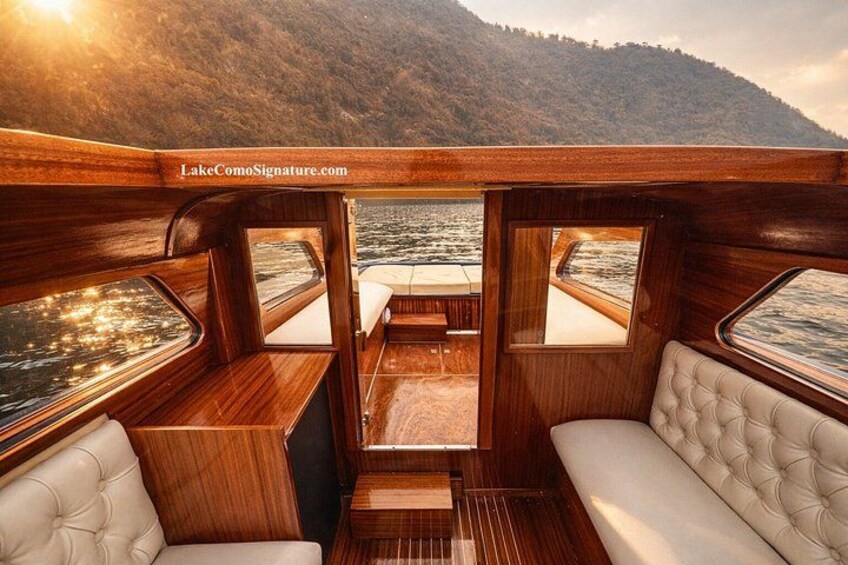 Interior de barco con muebles de madera y vista a un lago. 4