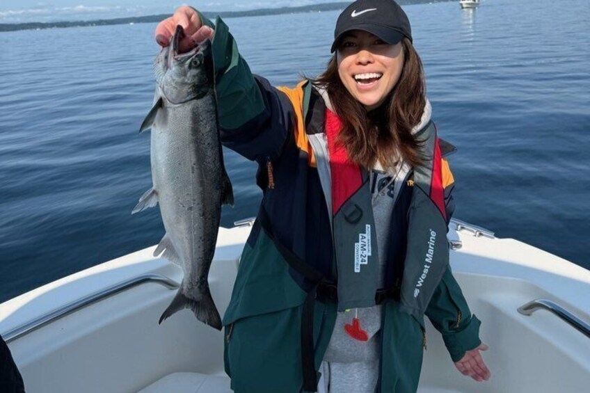 A person holding a fish on a boat. 4