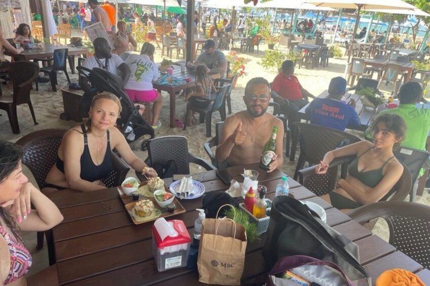 A group of people dining at an outdoor restaurant with tables and chairs. 4