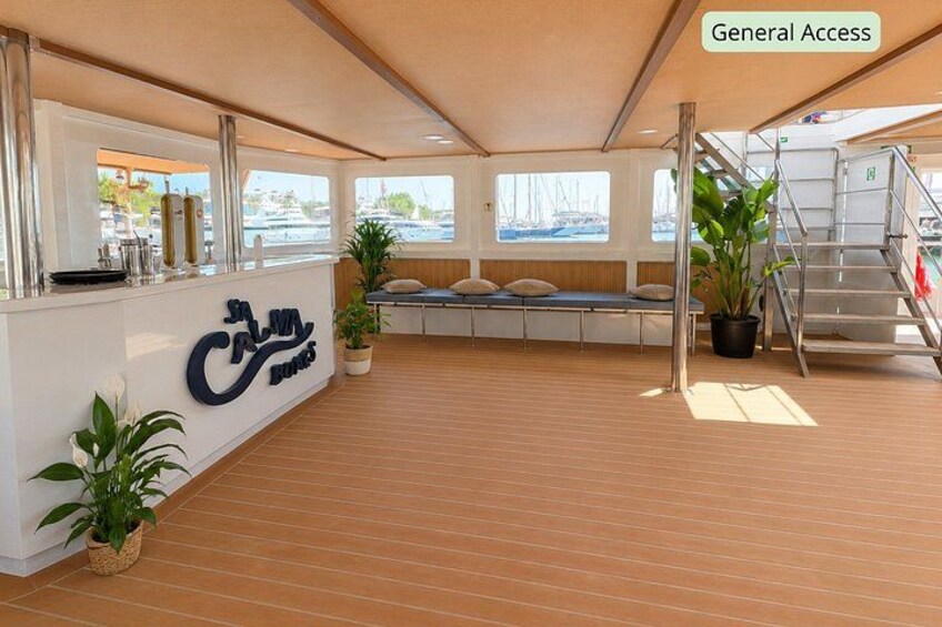A spacious deck with a reception area, potted plants, and a staircase leading to an upper level. 2