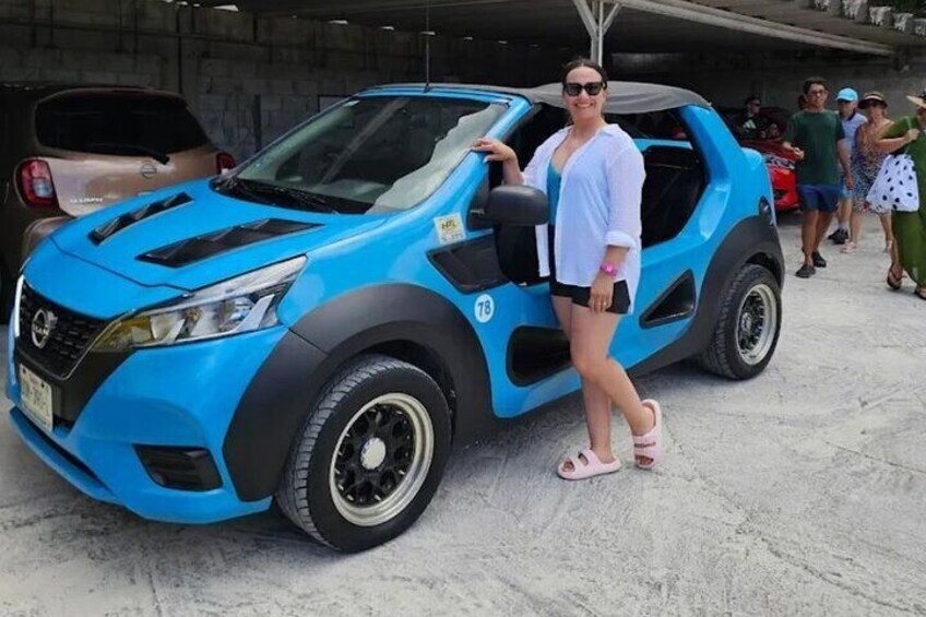 Un coche azul con el número de carrera 78 estacionado en una zona de hormigón junto a otros vehículos. 1