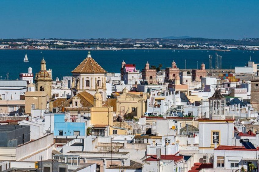 Un paysage urbain côtier, avec un mélange d’architecture historique et moderne, une église imposante et une vue dégagée sur la mer. 3