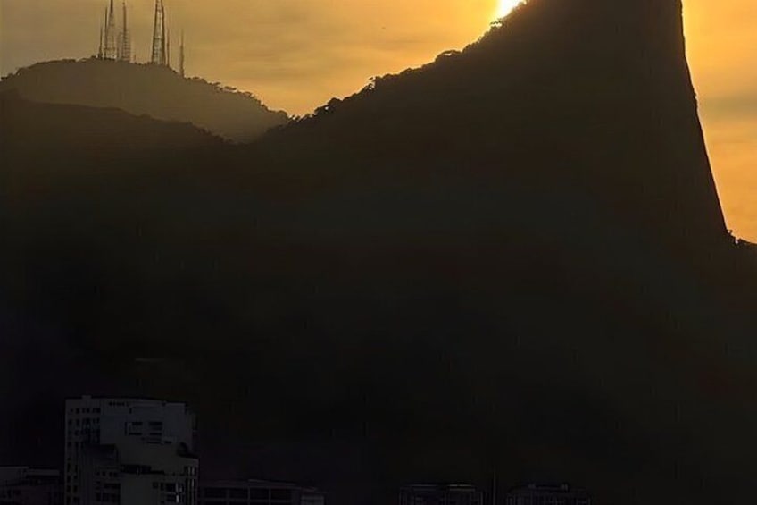 A mountain silhouette with a building at its base. 4