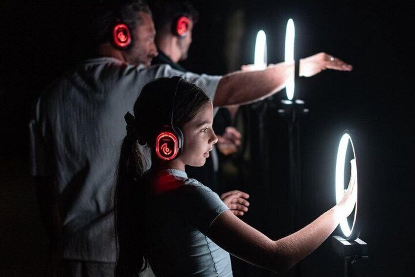 A person using a VR headset with a glowing light ring, another person in the background, and a VR light circle. 5
