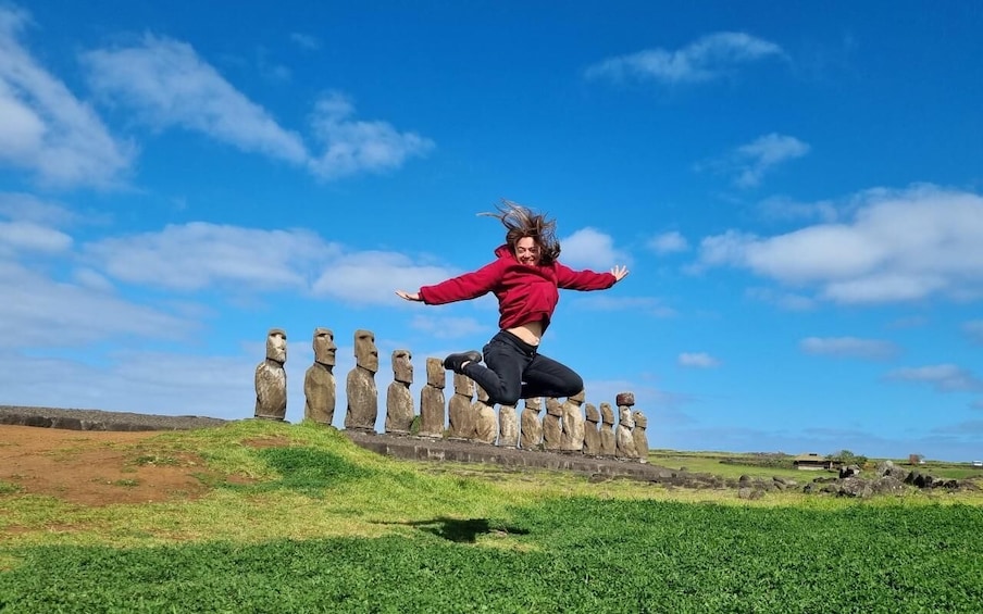 A person jumping in front of the Moai statues on Easter Island. 1