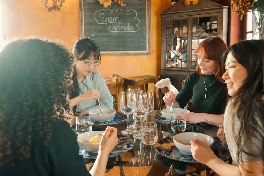 A group of people dining at a table with a chalkboard in the background displaying 'Bem Vindo'. 4