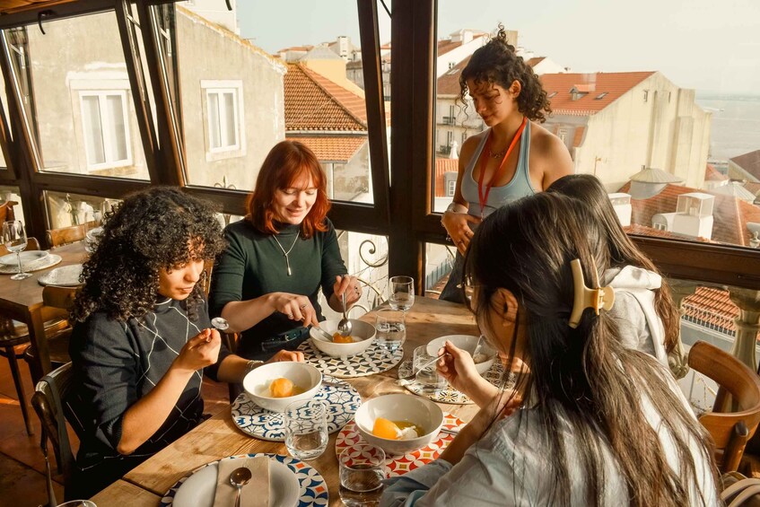 A group of people dining at a table with a view of buildings. 3