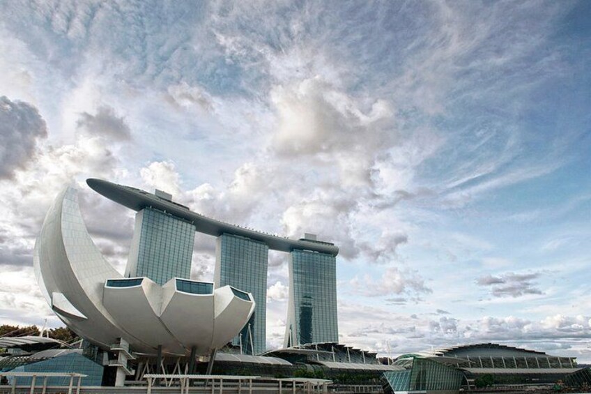 A modern architectural structure with a unique curved design, a large white dome-like feature, and a tall building with a pointed top. 2