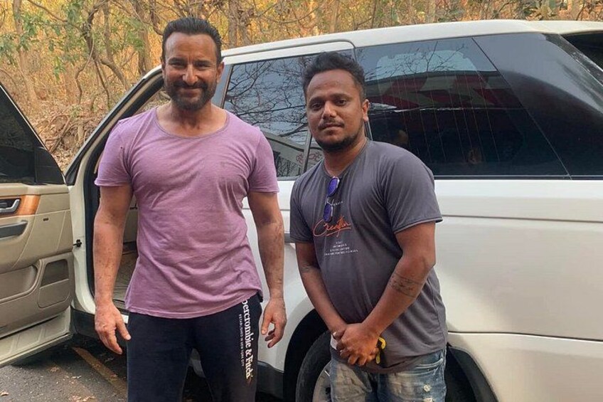 Two men standing next to a white vehicle with an open door. 3