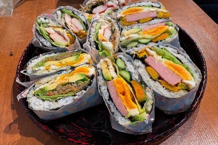 Forskellige sushi ruller anrettet på en mørk bakke. 1