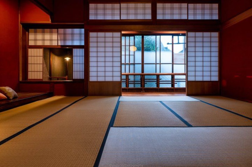 Et traditionelt japansk rum med tatamimåtter, skydedøre og et lavt bord. 4