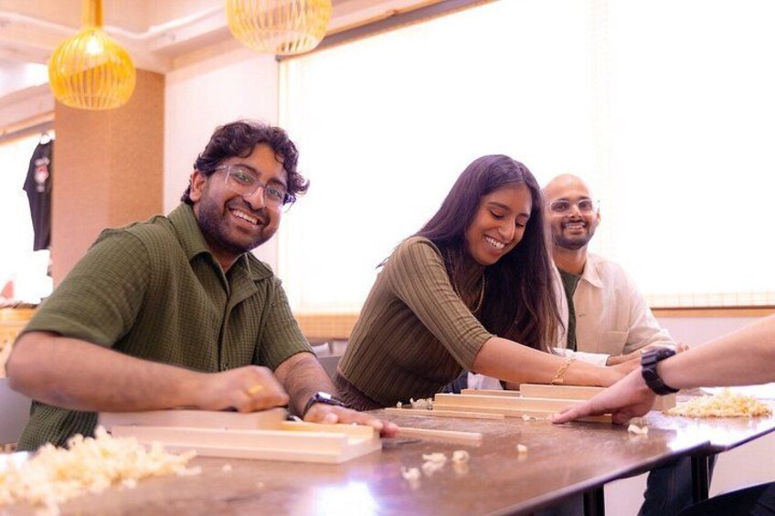 People engaged in a food preparation activity, with a focus on a person cutting cheese. 2