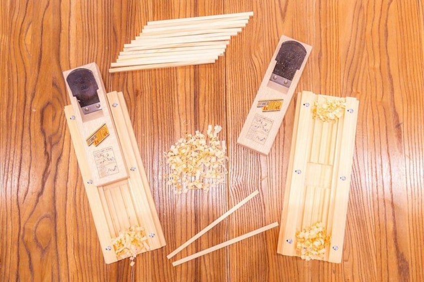 A wooden table with a set of wooden sticks, a small wooden device, and a pile of small wooden pieces. 4