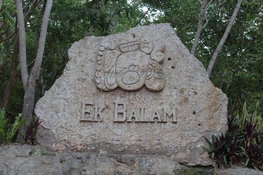 Ein großer Stein mit der Inschrift 'EK BALAM' und einem dekorativen Wappen. 4