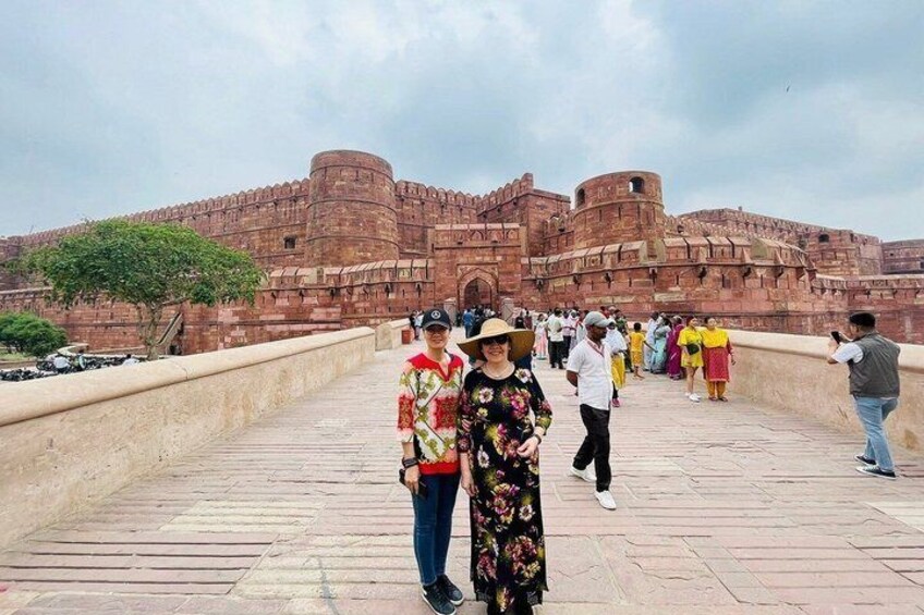 A historic fort with tourists on a bridge. 3