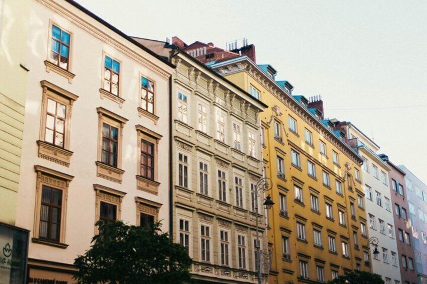 A row of multi-story buildings with varying architectural styles and colors. 3