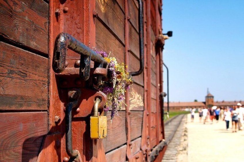 Een roestige metalen constructie met een hangslot en een boeket bloemen. 3