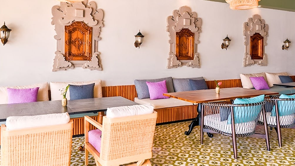 Ein Restaurantinneres mit Holzbeschilderung, gemustertem Boden und dekorativen Wandleuchten. 5