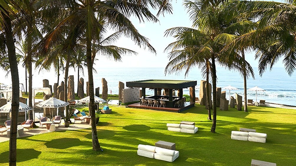 Ein Strandhotel mit Palmen, einem Poolbereich und Blick auf den Ozean. 3