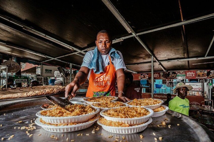Un vendedor de comida callejera prepara alimentos en un mercado. 5