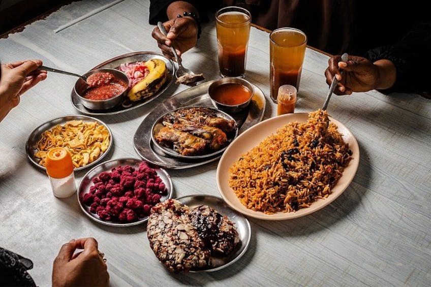 Una mesa con diversos platos, incluyendo un tazón grande de arroz, carne en platos y tazones de fruta. 2