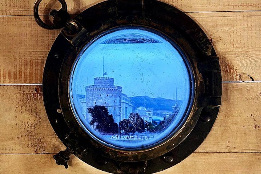 A round porthole window with a view of a castle-like structure. 3