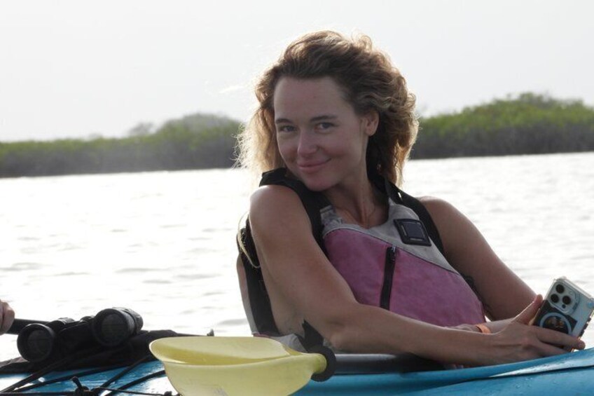 A person on a boat with a life jacket, a yellow bowl, and a smartphone. 4