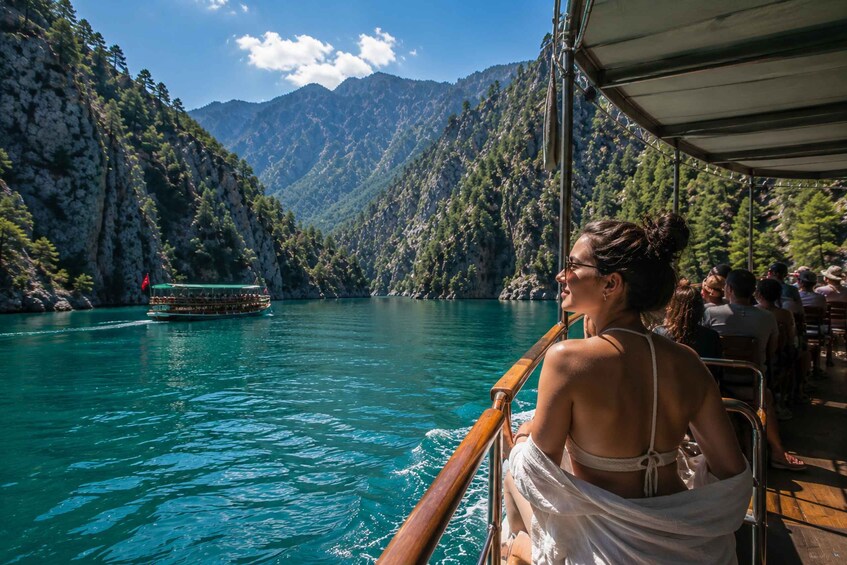 A boat on a turquoise lake surrounded by mountains. 4