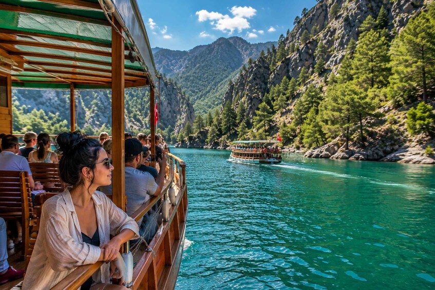 A boat with passengers on a river surrounded by mountains. 5