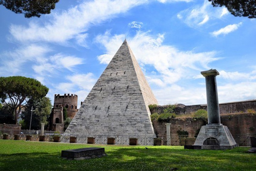 A large stone pyramid, a column, and a castle in the background. 1