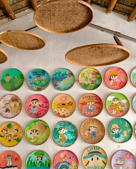 A collection of colorful painted wooden plates arranged in rows. 5