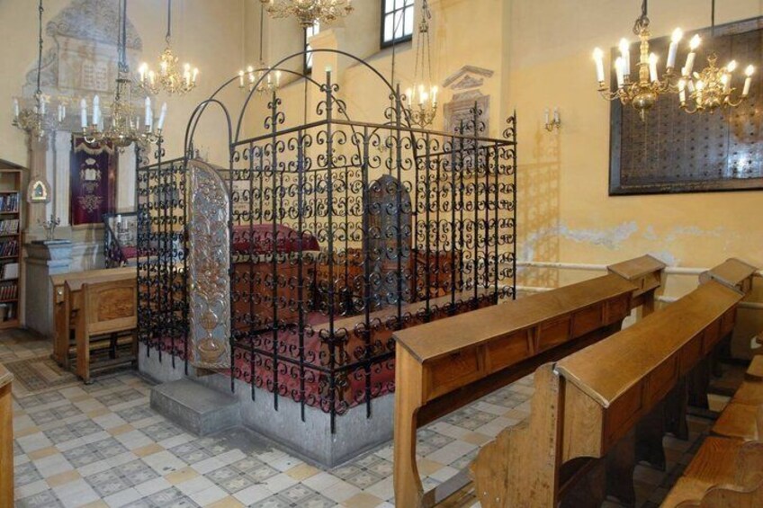 L’intérieur d’une église, avec ses bancs, une structure métallique ornée au centre et des lustres. 3