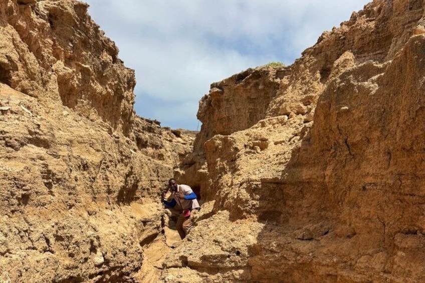 Eine Person erkundet eine schmale Schlucht mit steilen Wänden. 5