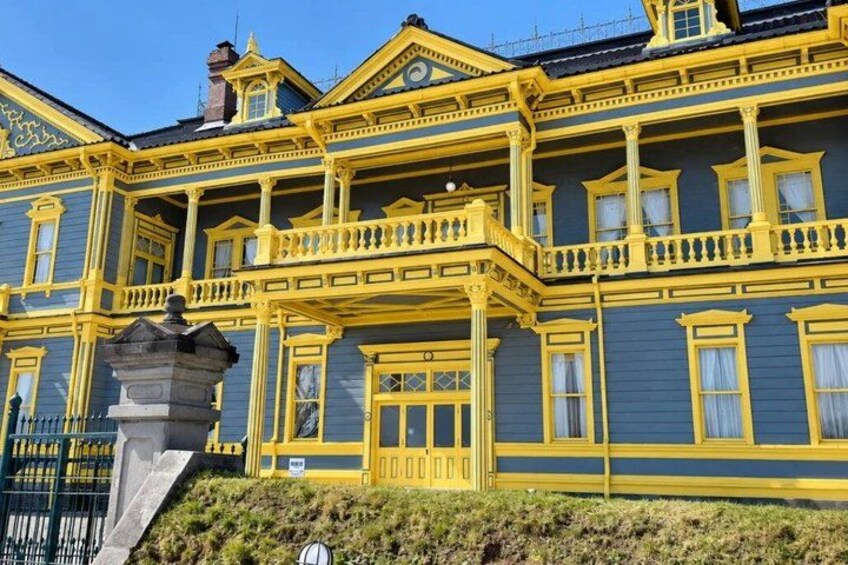 Un edificio grande y ornamentado con detalles amarillos y varios balcones. 3