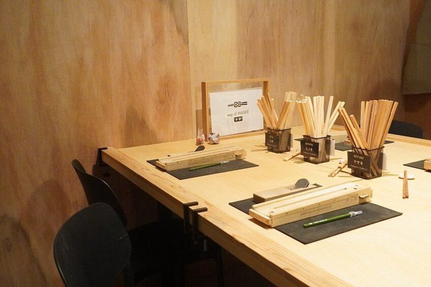 A wooden table with chopsticks, chopsticks holders, and a sign. 3