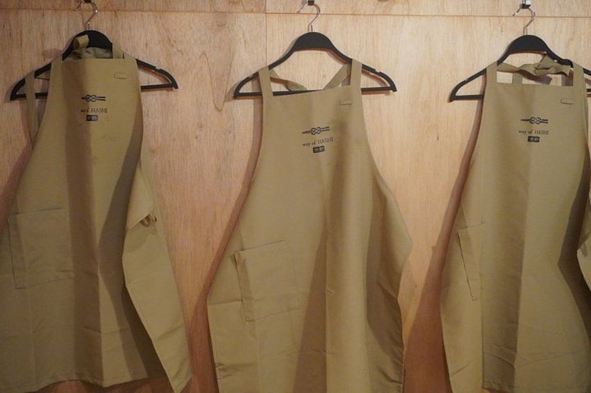 Three aprons hanging on a wooden wall. 2