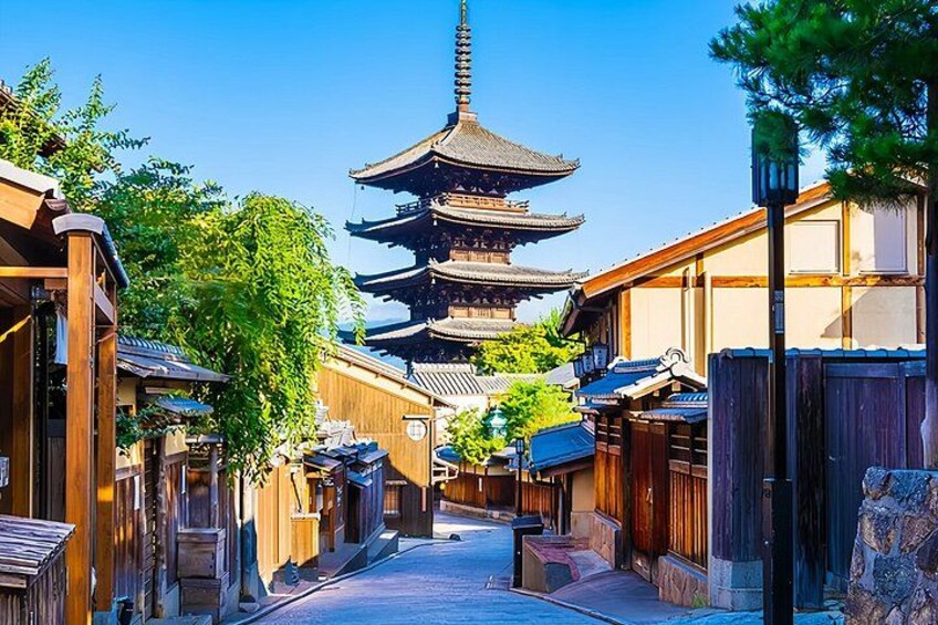 A traditional Japanese street with wooden buildings, a pagoda, and a clear blue sky. 3