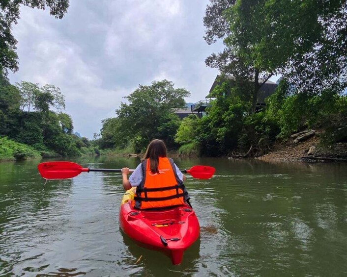 A person kayaking on a river surrounded by greenery. 2