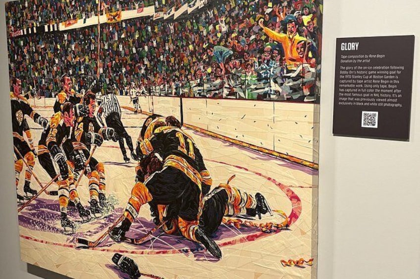 Ishockeykamp med spillere på isen, en dommer og et publikum i baggrunden. 5