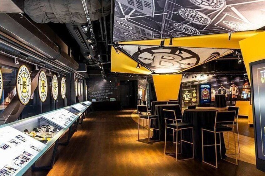 En butik med sportsmemorabilier, udstillingsmontre og en stor logo på loftet. 3