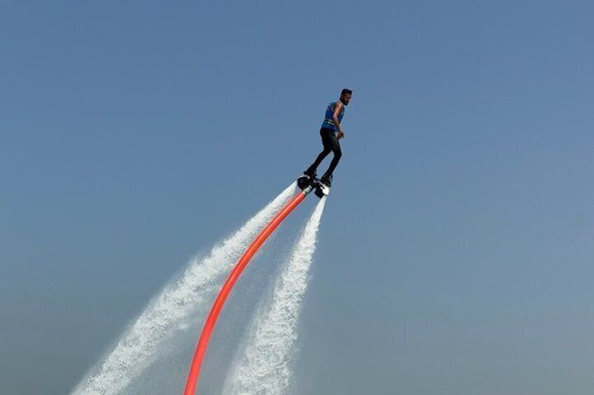 Una persona che fa jet ski, spruzzi d'acqua e cielo sereno. 5