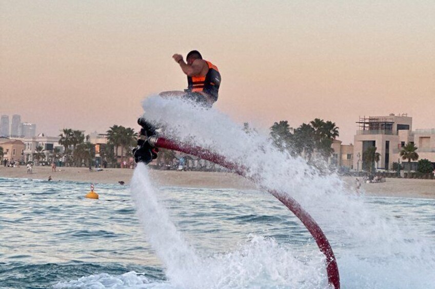 Una persona che fa jet ski sull'acqua, con uno skyline urbano sullo sfondo. 2
